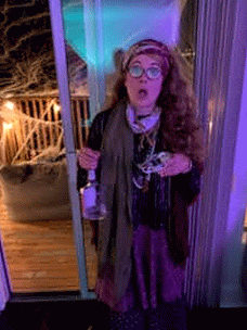 A gif of a girl with long curly hair dressed up as Professor Trelawny, with lots of shawls and a slightly crazed look in my eyes.